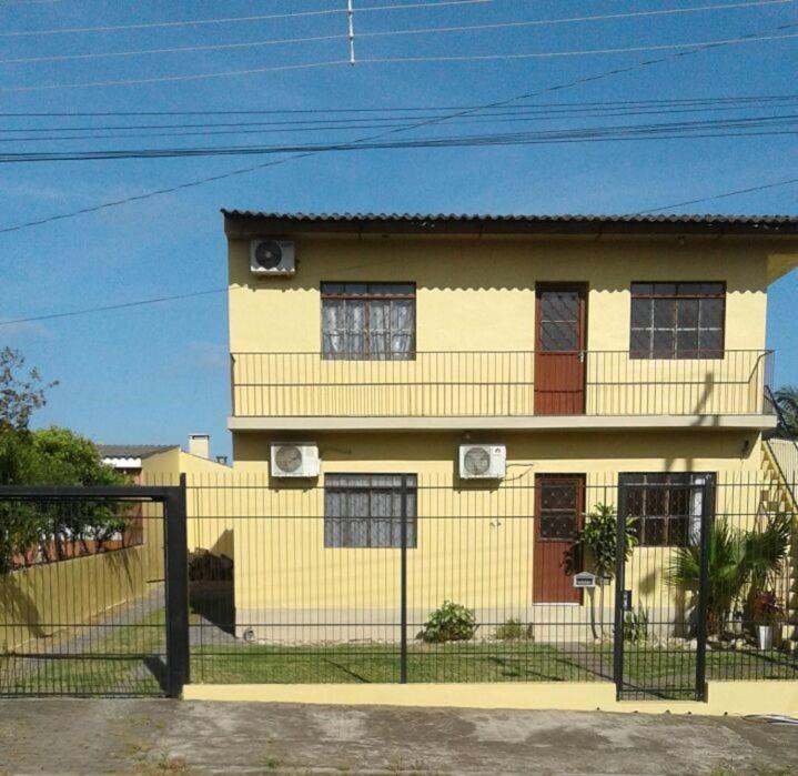 una casa amarilla con una valla delante de ella en Pousada Cantinho do João Gabriel, en São Gabriel