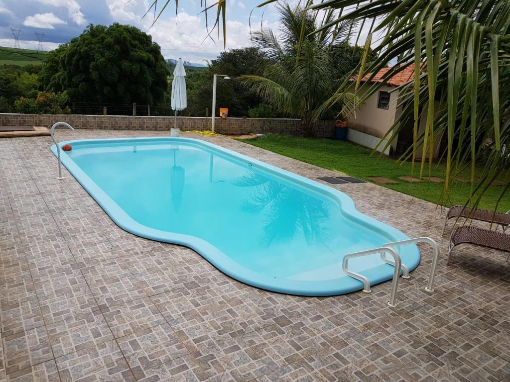 a large blue swimming pool in a yard at Sitio Dois Irmãos in Piumhi