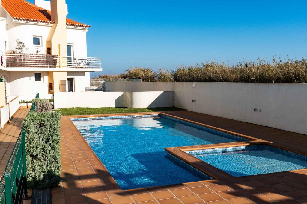 a swimming pool in the backyard of a house at Apartments Baleal: Sunshine by the Pool in Ferrel