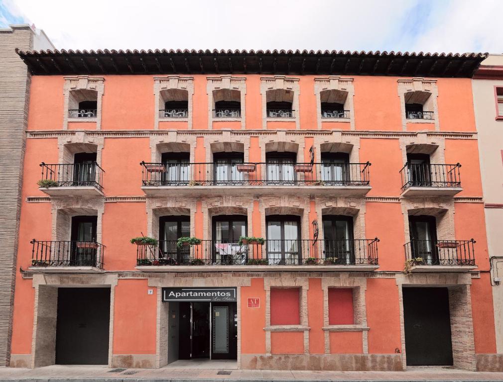 ein großes orangefarbenes Gebäude mit Fenstern und Balkonen in der Unterkunft Casa Palacio de los Sitios in Saragossa