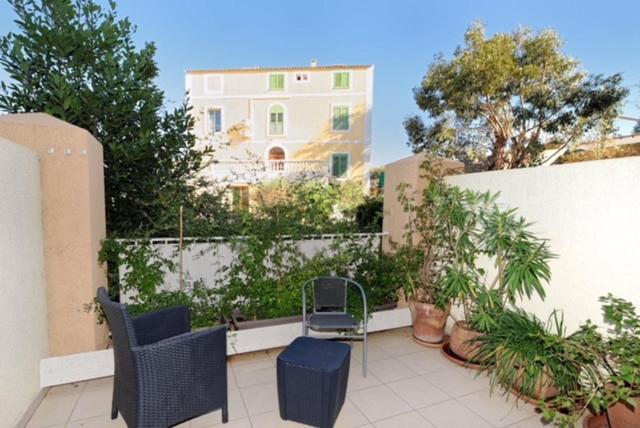 une terrasse avec des chaises, des plantes et une clôture dans l'établissement Résidence les Eucalyptus, à LʼÎle-Rousse