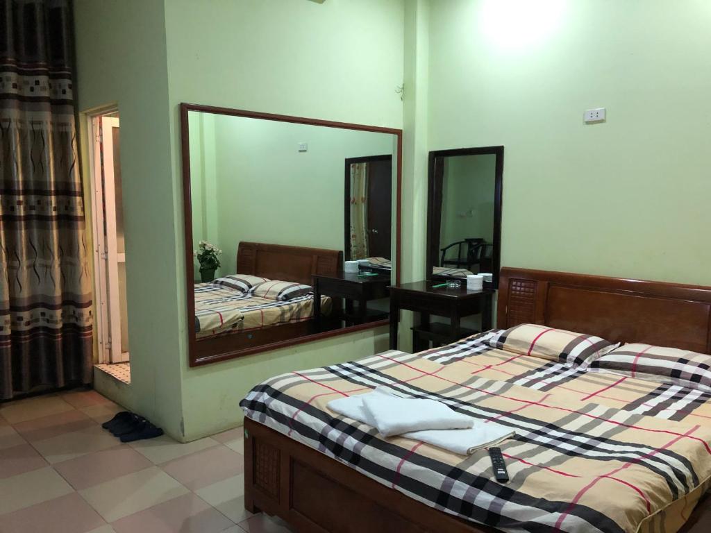 a bedroom with a bed and a large mirror at Nhà nghỉ An Phú in Hanoi