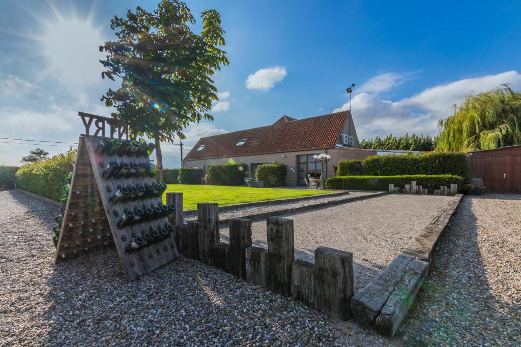 a wooden fence and a tree in front of a house at Apollonia in Aalter