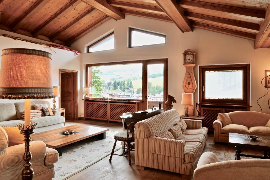 uma sala de estar cheia de mobiliário e uma grande janela em CanguroProperties - Ca' Mora em Cortina dʼAmpezzo