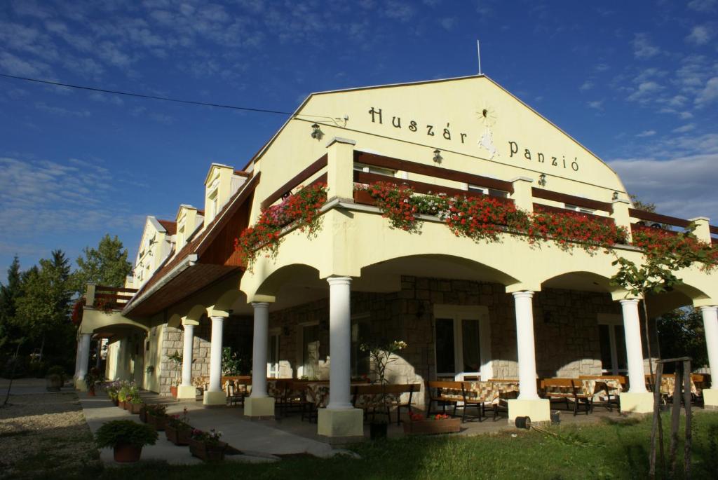 een gebouw met bloemen aan de voorkant bij Huszár Panzió és Étterem in Sárospatak