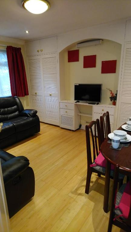 Μια τηλεόραση ή/και κέντρο ψυχαγωγίας στο Christchurch Guesthouse 2-Bed Apartments