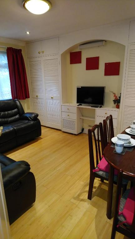 a living room with a couch and a table at Christchurch Guesthouse Apartments in Harrow Weald