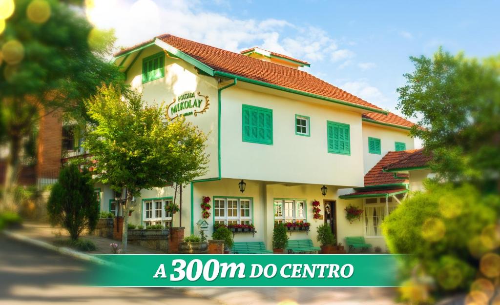 a large white building with a red roof at Pousada Mikolay in Gramado