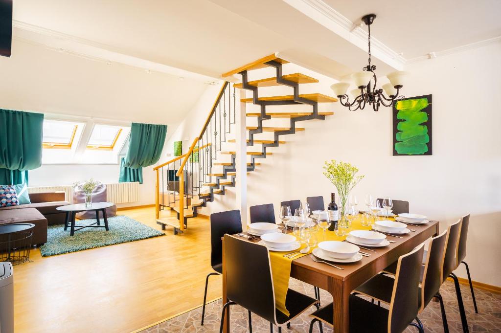 a dining room with a table with chairs and a staircase at HOME ALONE 5BR+3BATH Penthouse in center of Prague in Prague
