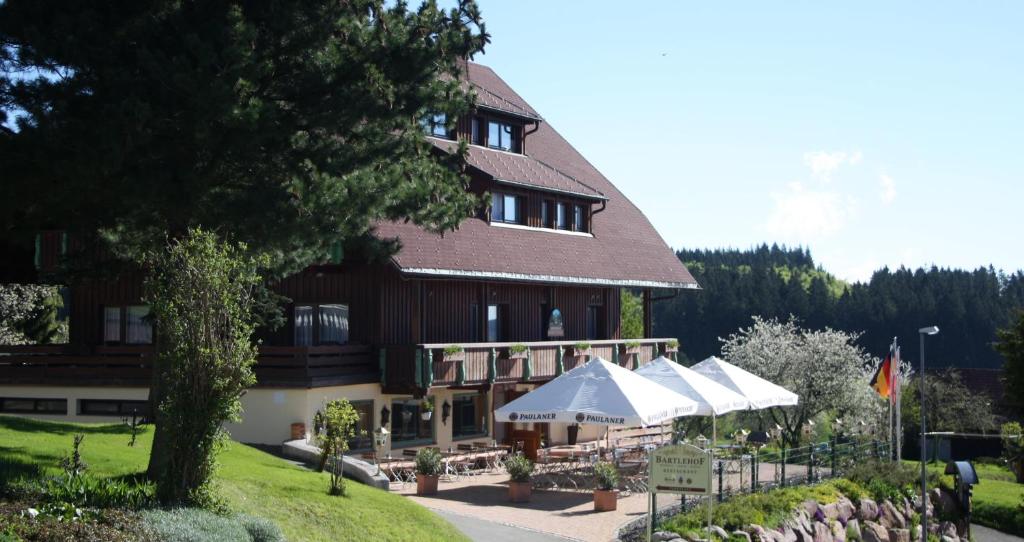 a large building with umbrellas in front of it at Landhotel Bartlehof in Schluchsee