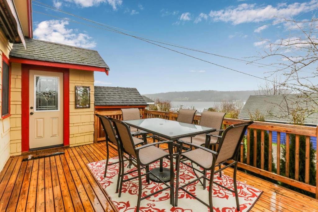 a patio with a table and chairs on a deck at Bay View Bungalow in Poulsbo