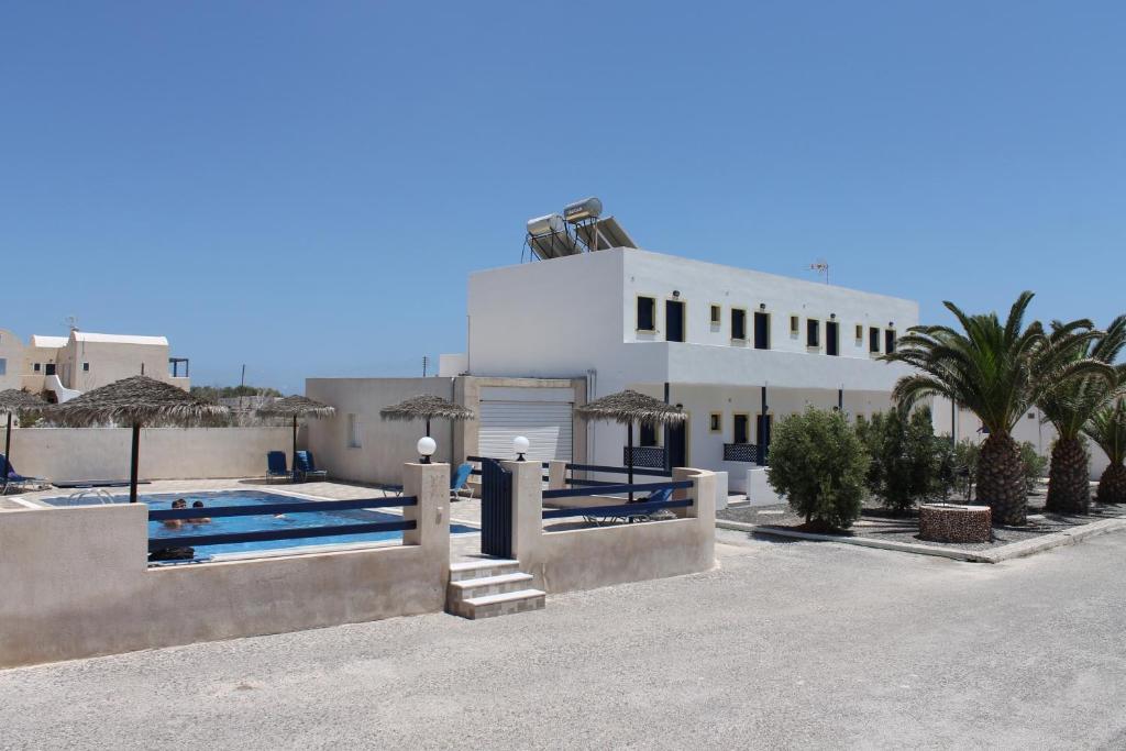 un edificio bianco con piscina e palme di Mary Rooms a Perivolos