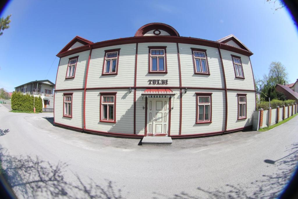 un grande edificio bianco con una porta su una strada di Tulbi Guesthouse a Pärnu