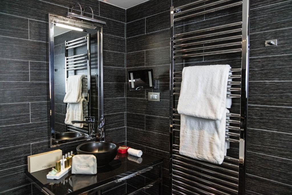 a black bathroom with a sink and a mirror at Avenue Lodge Hotel & Spa in Val-d'Isère