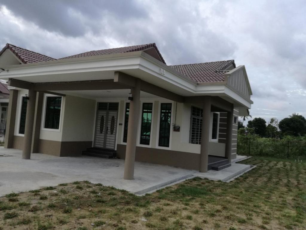 a small house with a porch at Homestay Pasir Tumboh Kota Bharu in Kota Bharu