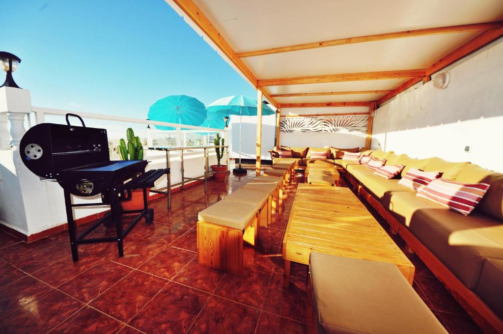 a balcony with couches and a piano on a ship at Hola Surf Morocco in Agadir