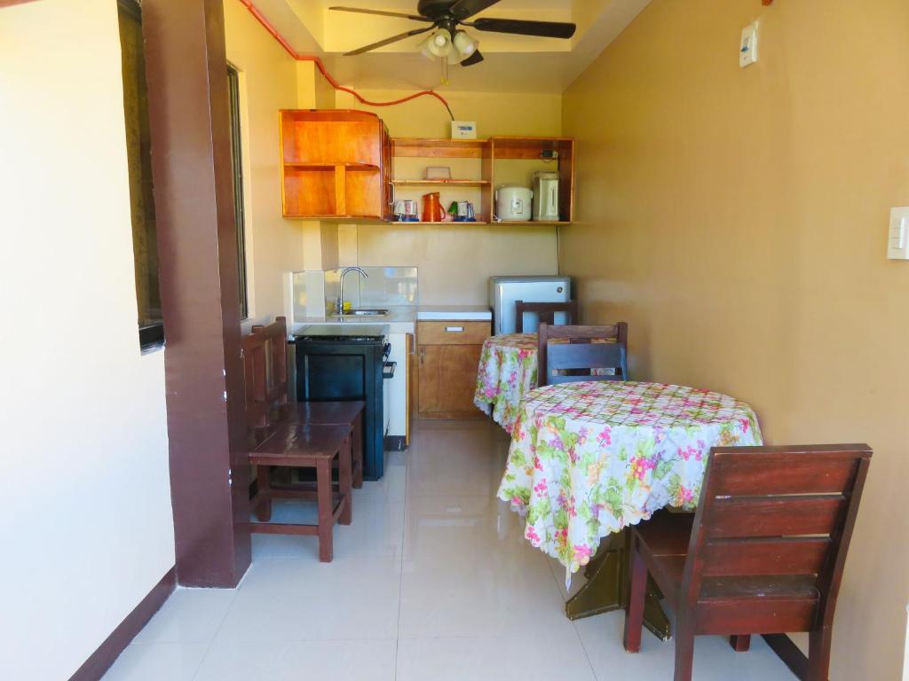 a kitchen with two beds and a table and chairs at Nanette's Tourist Inn in Bantayan Island