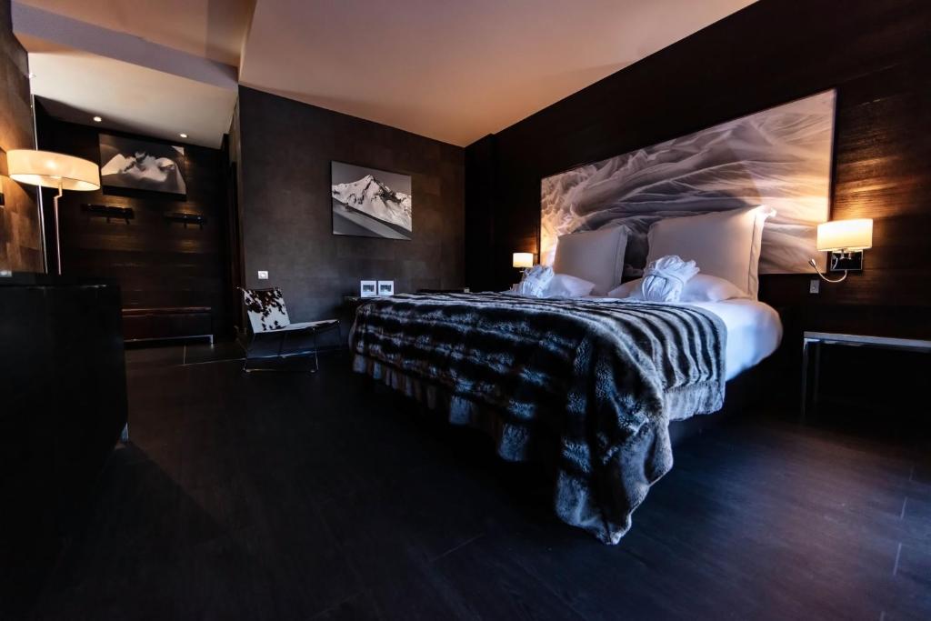 a bedroom with a large bed in a room at Avenue Lodge Hotel & Spa in Val-d'Isère