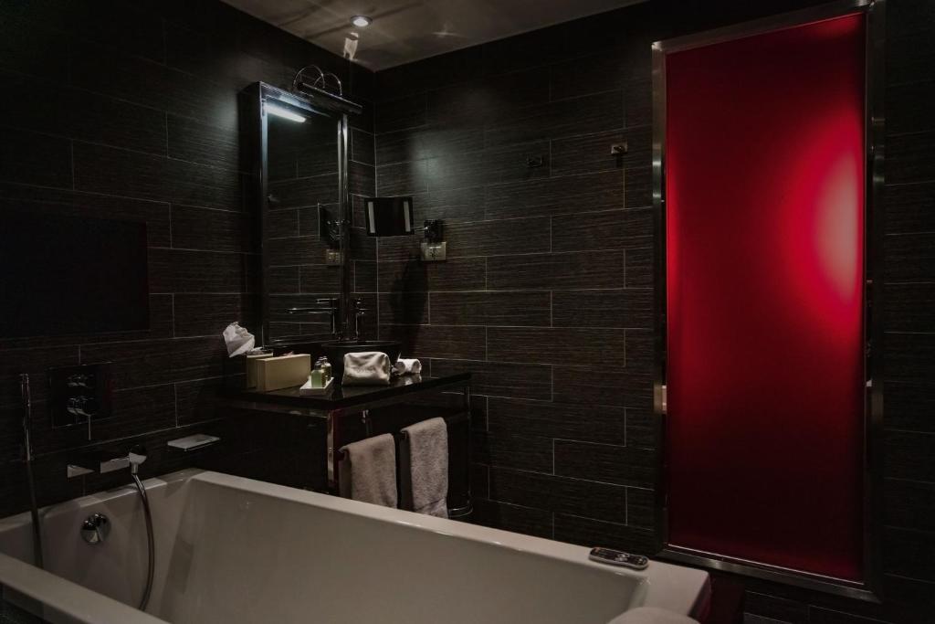 a bathroom with a bath tub and a red light at Avenue Lodge Hotel & Spa in Val-d'Isère