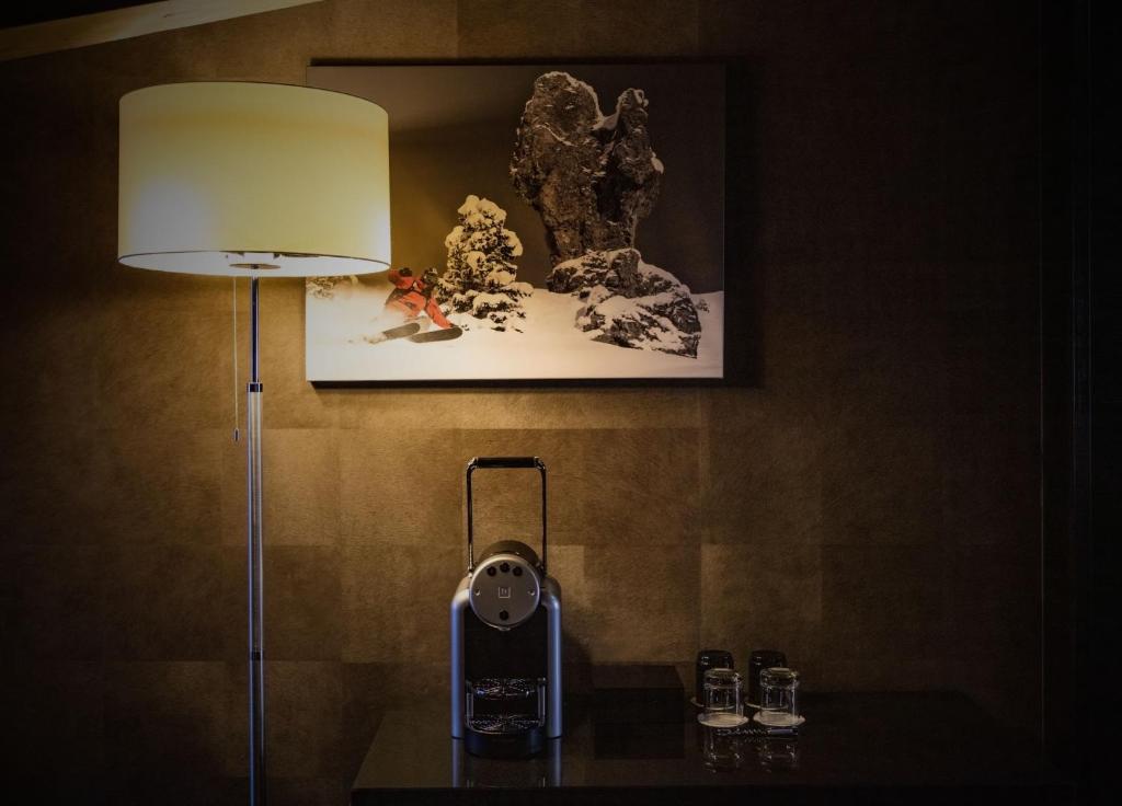 a lamp on a table with a phone on it at Avenue Lodge Hotel & Spa in Val-d'Isère