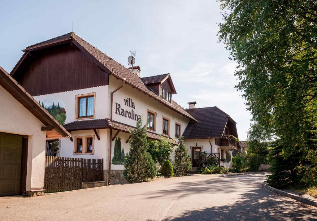 a building with a sign on the side of a road at Villa Karolina in Prášily