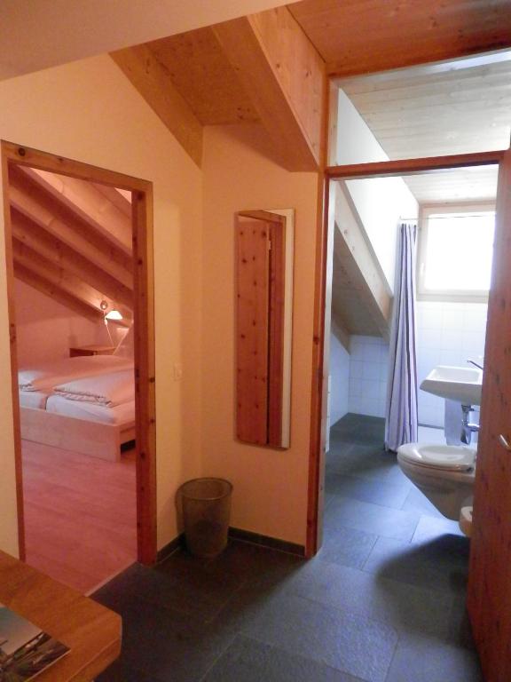 a bedroom with a bed and a bathroom with a toilet at Palazzo Mysanus Samedan in Samedan