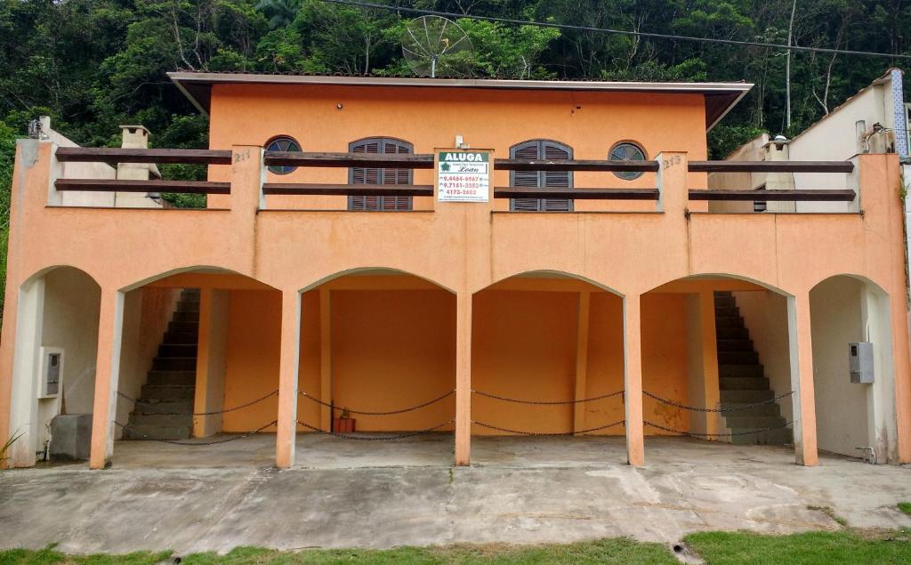 Casa de Praia Loan في كاراغواتاتوبا: مبنى برتقالي فوقه شرفة