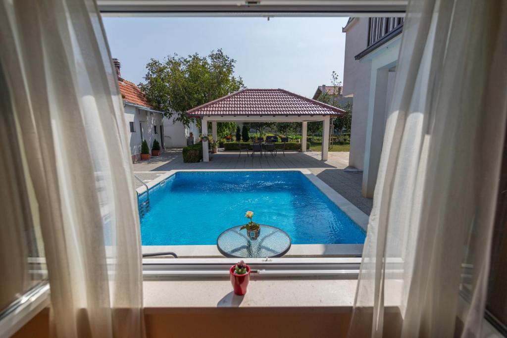Blick auf den Pool durch ein Fenster in der Unterkunft Holiday Home Mirela in Studenci