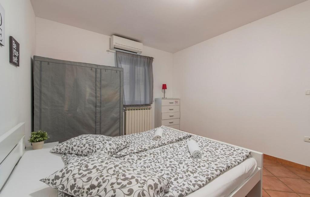 sypialnia z łóżkiem z czarno-białą kołdrą w obiekcie Apartment Narcisa with Terrace w mieście Umag