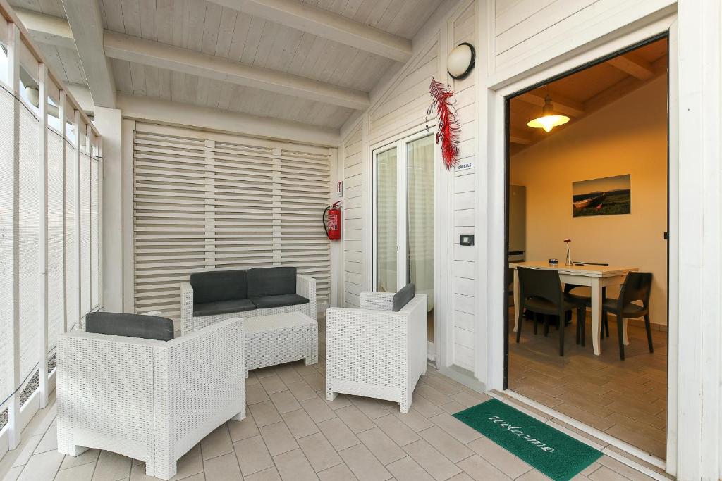 een veranda met witte rieten stoelen en een tafel bij Agricampeggio Alessandra in Torrenova