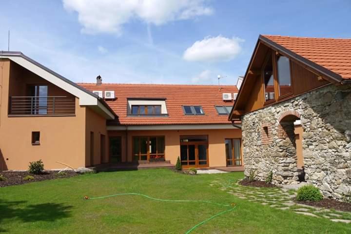 a house with a yard with a green hose at Domeček Milevsko in Milevsko