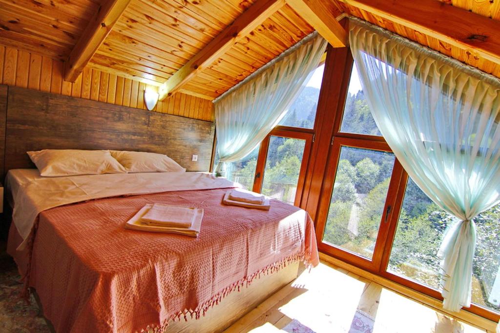 a bedroom with a bed and a large window at Ayder İmamoğlu Apart Otel in Ayder Yaylasi