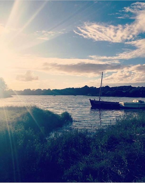 un bateau assis dans l'eau sur un lac dans l'établissement Maison avec vue, à Pouldouran