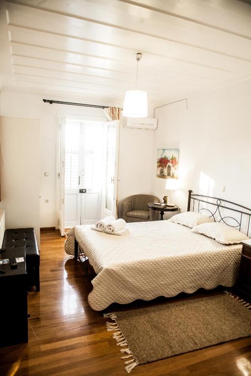 a white bedroom with two beds and a window at La Casa di Caterina in Lefkada