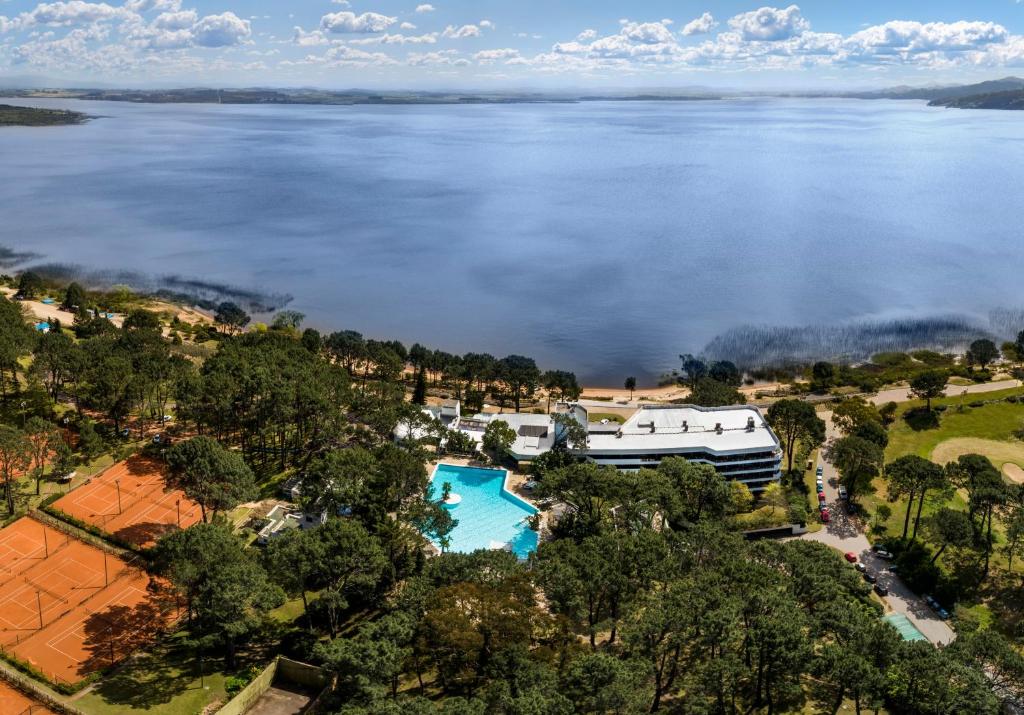 uma vista aérea de uma casa ao lado de uma massa de água em Hotel del Lago Golf & Art Resort em Punta del Este