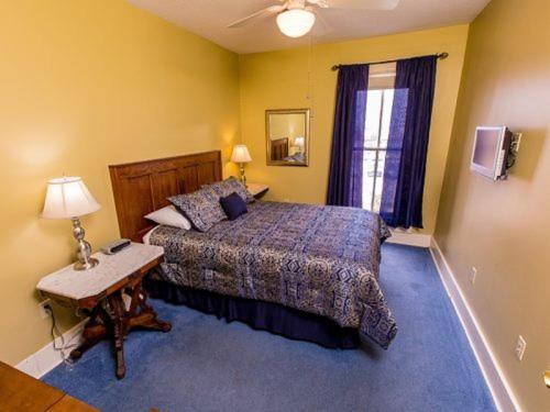 a bedroom with a bed and a table and a window at Victoria Inn in Erie