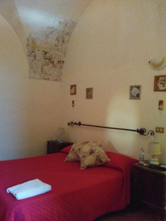 ein Schlafzimmer mit einem roten Bett mit einer roten Decke in der Unterkunft BB Dimora San Pietro in Ferrandina