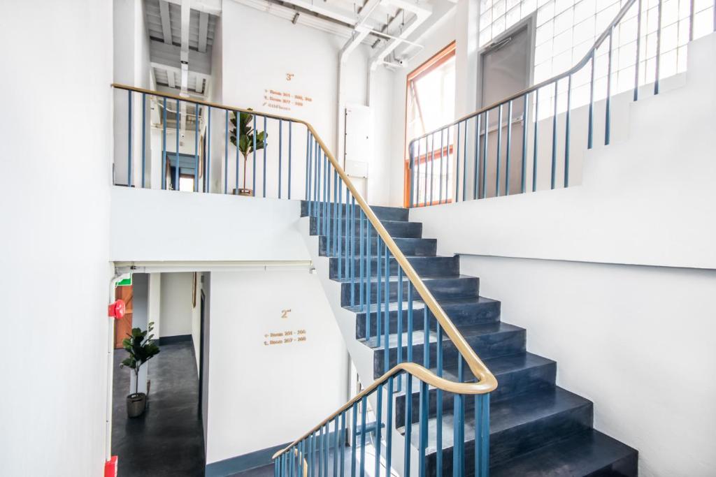 un escalier dans un bâtiment de bureau avec des escaliers bleus et blancs dans l'établissement Mimi and Jim Co-living space, à Cha Am