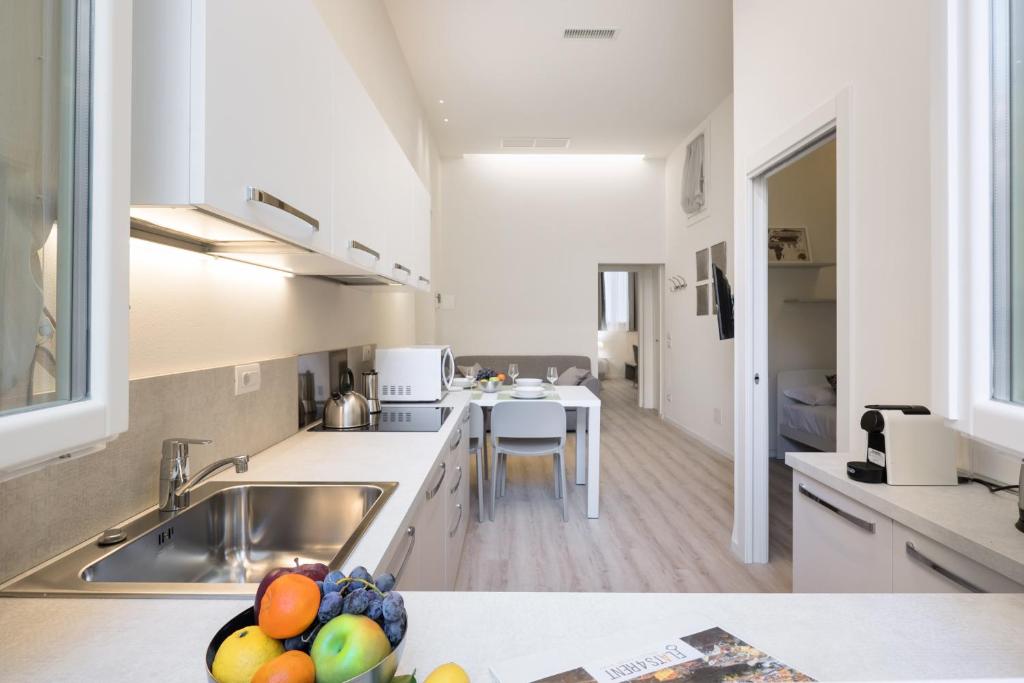 - une cuisine avec un évier et un comptoir avec un bol de fruits dans l'établissement Duomo apartment, à Vérone