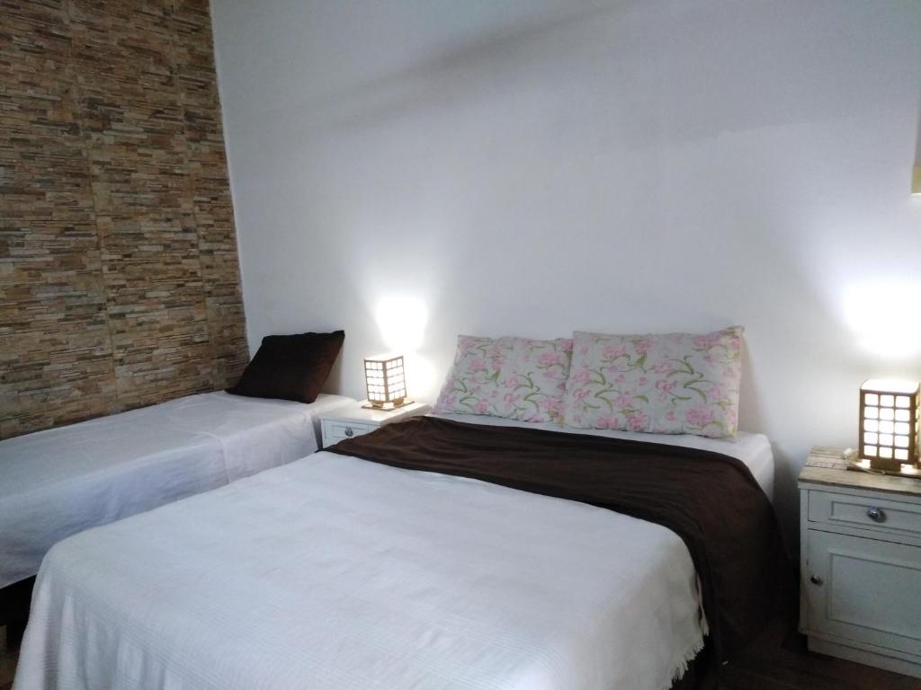 1 Schlafzimmer mit 2 Betten und Ziegelwand in der Unterkunft Granados in Asunción