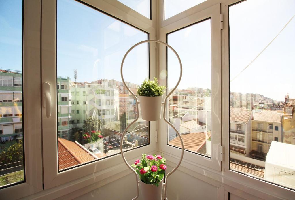 uma janela com dois vasos de flores no parapeito da janela em Poppy house in Anjos em Lisboa