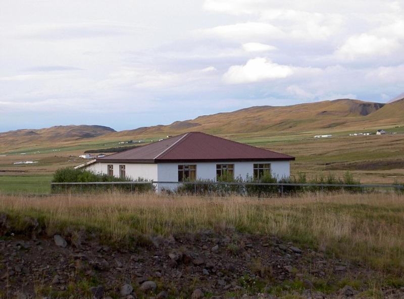 una casa bianca in mezzo a un campo di Solvanes Farmholidays a Varmahlíð