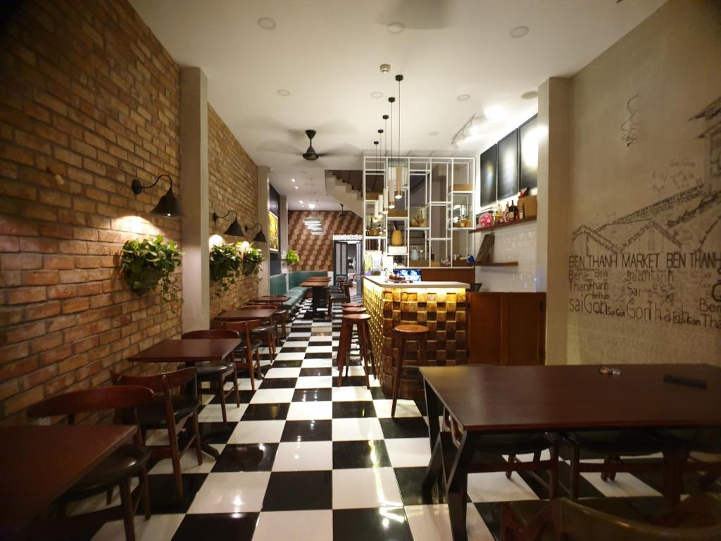a restaurant with tables and chairs on a checkered floor at Beauty House in Ho Chi Minh City