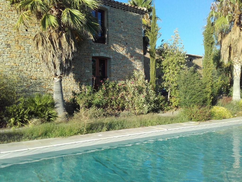 una casa y una piscina frente a un edificio en Studios Domaine l'Oliveraie en Le Castellet