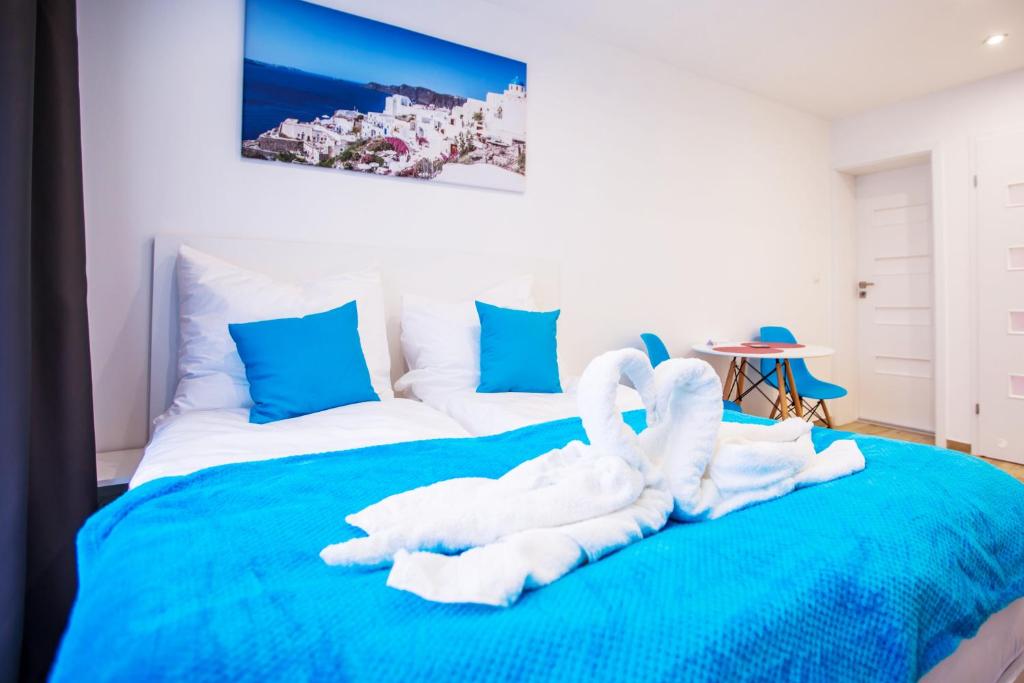 1 dormitorio con 2 cisnes hechos de toallas en una cama en Adonis Apartments, en Świnoujście