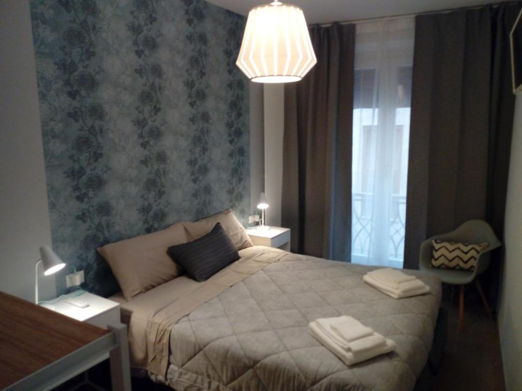 een slaapkamer met een bed en een kroonluchter bij Bologna House Due Torri Apartment in Bologna