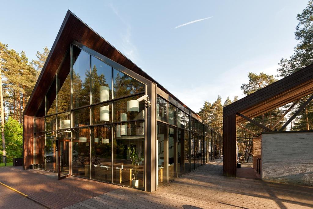 a glass house with trees in the background at Belvilis Hotel in Molėtai