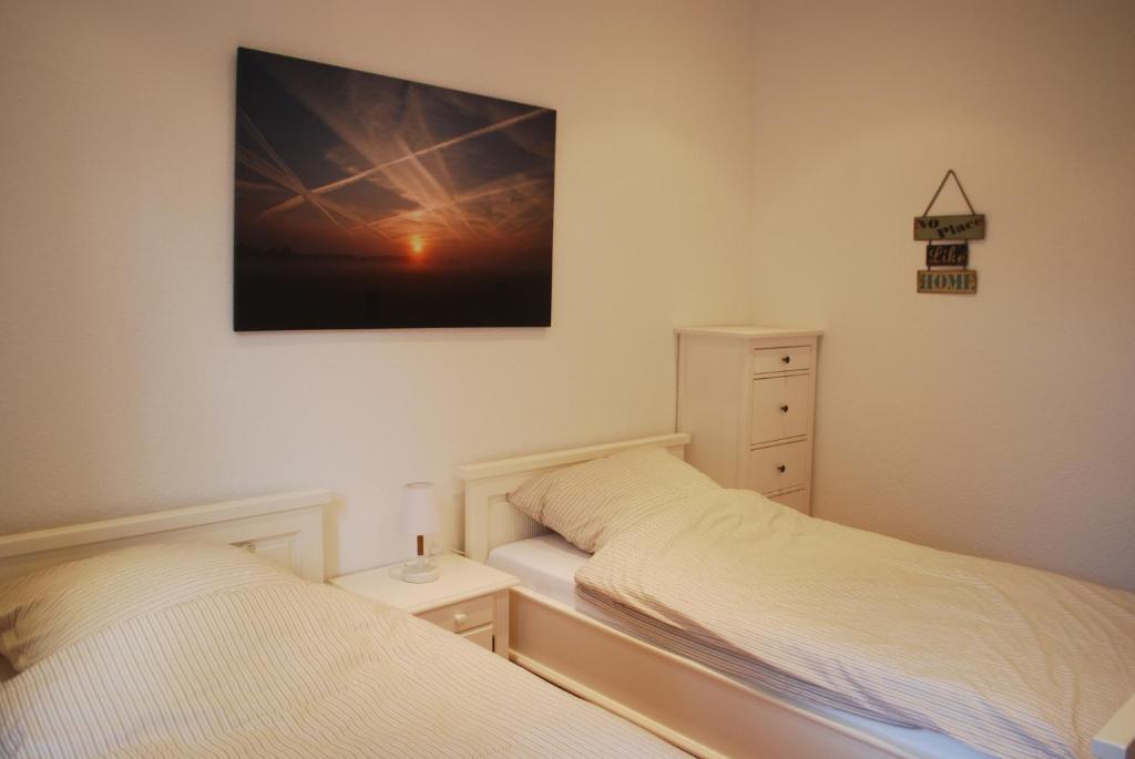 a bedroom with two beds and a picture on the wall at Ferienwohnung im Grünen - Hof Blohme in Langwedel