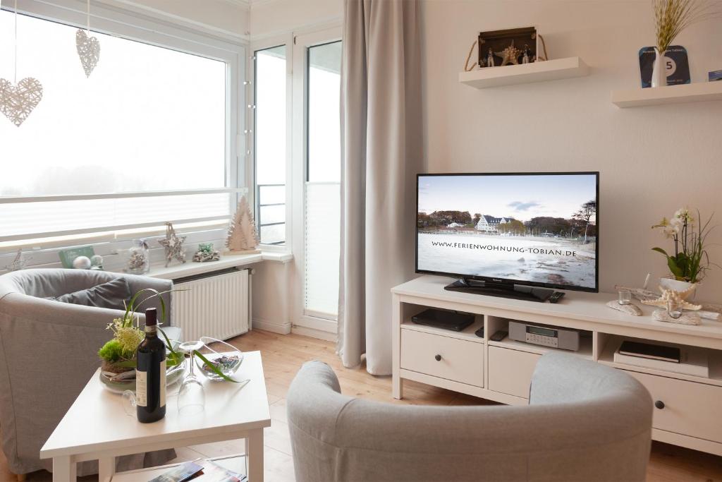 sala de estar con TV de pantalla plana sobre una mesa en Ferienwohnungen Tobian, en Glücksburg