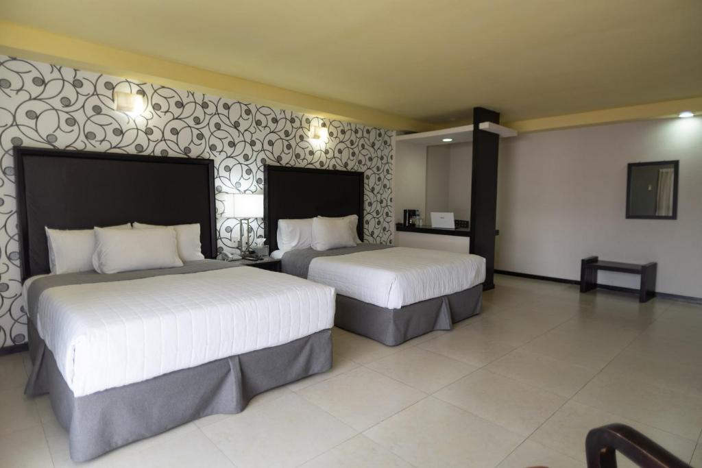 una habitación de hotel con 2 camas en una habitación en Hotel Ha en Orizaba